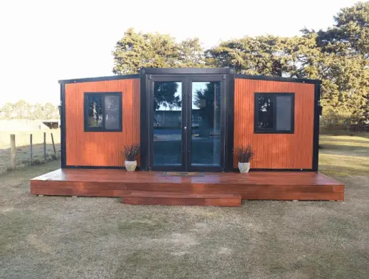 20ft expandable house in NZ – front view with timber deck and glass doors (Portable Dwellings)