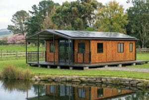 Portable off-grid home in New Zealand set on a rural lifestyle property with solar panels and pond